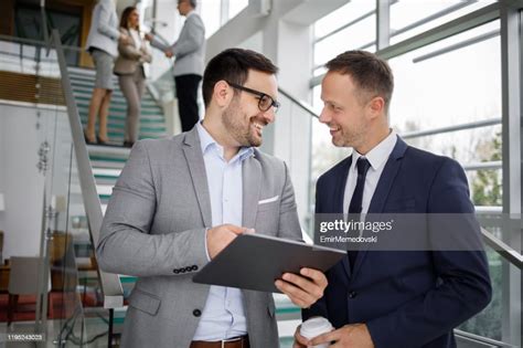 Two Businessmen Sharing Corporate Ideas Using A Digital Tablet In