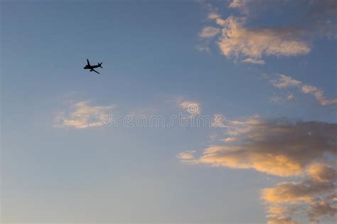 Low Angle Shot Of An Airplane Silhouette On Cloudy Sky Background Stock