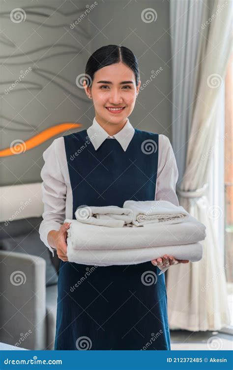asian hotel maid holding fresh towels prepare for new hotel guest in bedroom stock image image