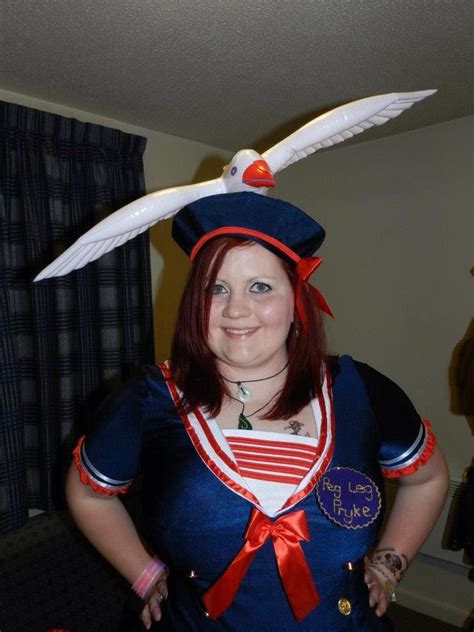 a woman dressed as a sailor with an eagle on her head and red ribbon around her neck