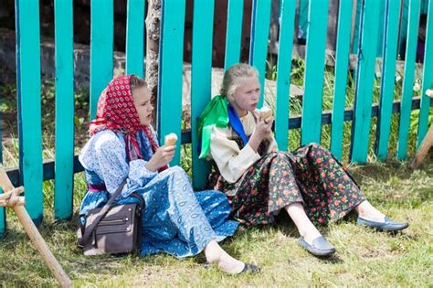 editorial niñas en trajes folclóricos rusos sentados en el suelo y comiendo helado foto premium