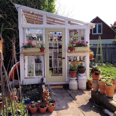 A Small Greenhouse With Potted Plants And Flowers In The Window Boxes