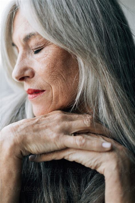 closeup portrait of an attractive senior woman with grey long hair by stocksy contributor