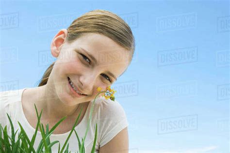 Preteen Girl Leaning Cheek Against Flower Stock Photo Dissolve