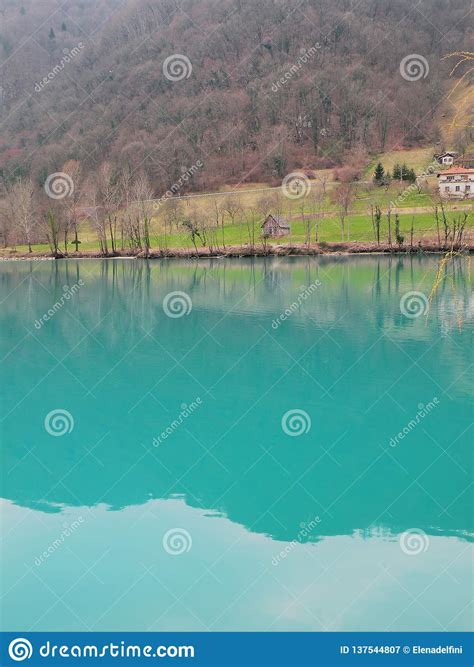 Mountain Lake With Turquoise Blue Water Surrounded By Alps And Green