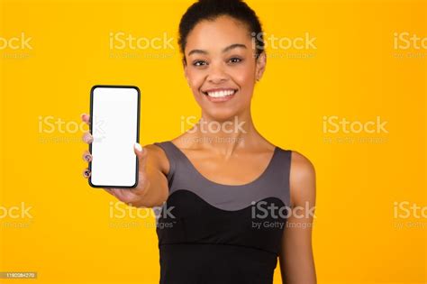 Fit Black Girl Showing Phone Blank Screen Standing Yellow Background