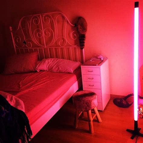 A Bedroom With A Bed Night Stand And Pink Light