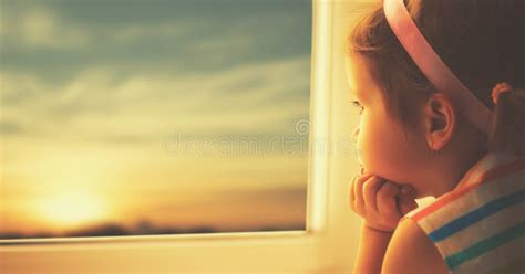 Child Sad Little Girl Looking Out Window At Sunset Stock Photo Image