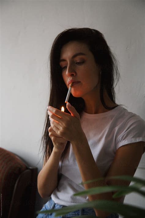 Woman Lighting Up A Smoke Del Colaborador De Stocksy Danil Nevsky