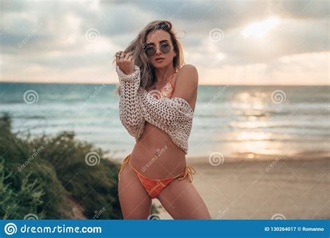 Curly Haired Blonde Model Wearing Sunglasses Swimsuit And Tunic Is