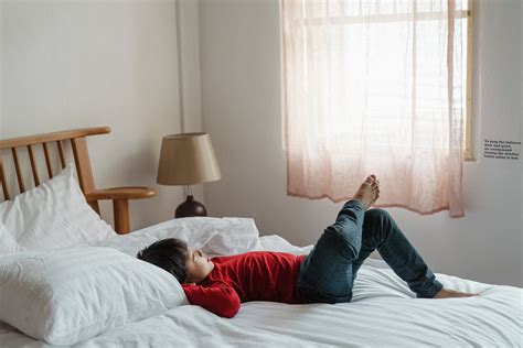 Photo Of Boy Lying Down On Bed · Free Stock Photo