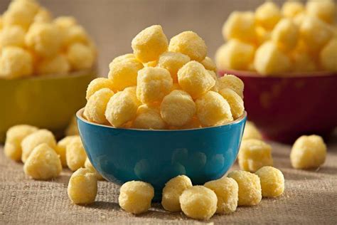 Fate scaldare dell'olio di semi per friggere all'interno di una padella antiaderente e mettete dentro le palline. Patatine Puff fatte in casa, uno snack sfizioso e veloce
