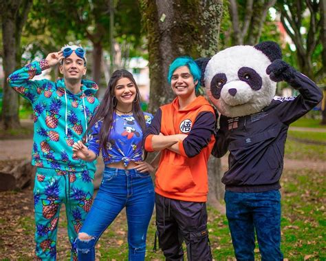 Four People Posing For A Photo With A Panda Mascot