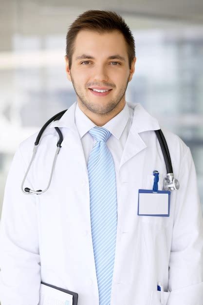 Premium Photo Smiling Doctor Man Standing Straight In Hospital
