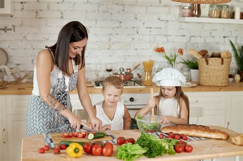 Familia Prepara El Almuerzo En La Cocina Mamá Enseña A Su Hija E Hijo