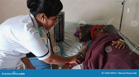 An Indian Hospital Female Staff Controlling Glucose Bottle Liquidity