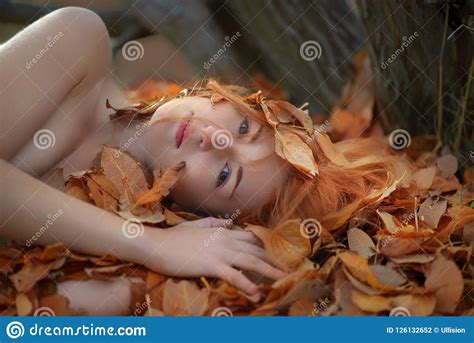 Beautiful Lovely Young Girl Lying On Golden Autumn Leaves Covered With Colored Leaves With