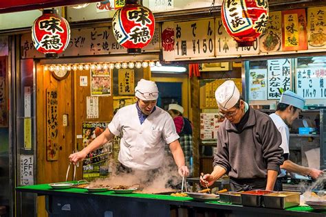 Chefs Cooking Traditional Japanese Street Food On The Streets Of Osaka