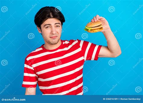 Photo Of Doubtful Moody Young Guy Dressed Red T Shirt Holding Junk Food