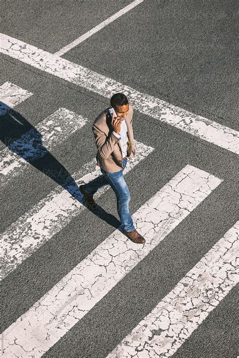 Black Businessman Walking And Talking With Cell Phone On A City