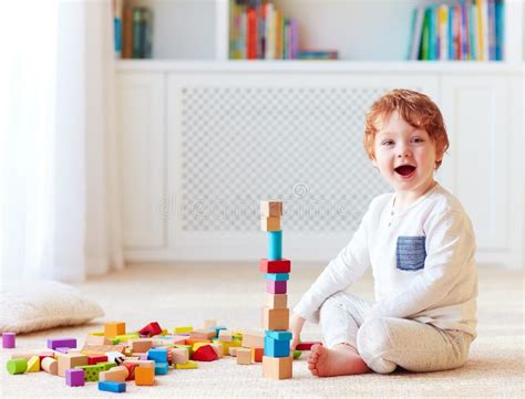 Cute Toddler Baby Boy Playing With Wooden Blocks Building A High Tower