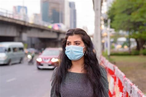 Young Indian Woman With Mask Thinking In The City Streets Outdoors