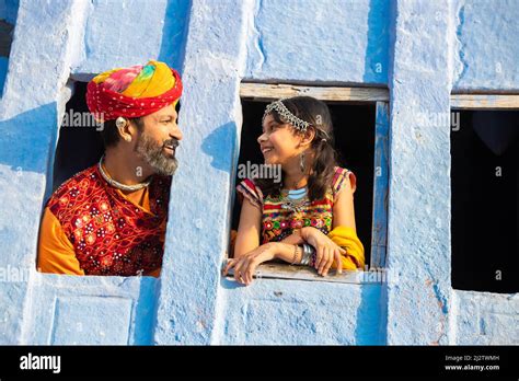 happy indian father daughter wearing traditional colorful rajasthani outfit looking looking out
