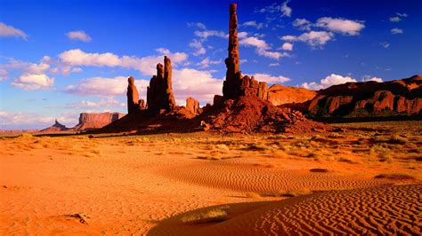 Towers Of Red Rock Desert Area With Red Sand And Rocks