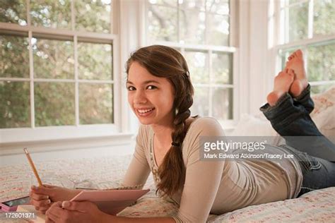 Mixed Race Teenage Girl Doing Homework On Bed Bildbanksfoton Och Bilder