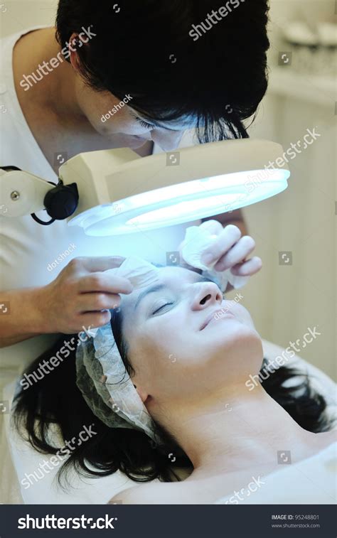 Young Beautiful Woman Receiving Cosmetic Facial Mask In Spa Beauty