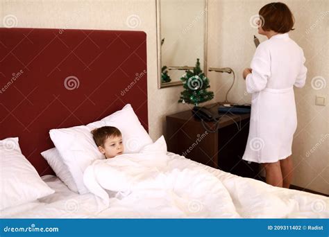 Mother And Son Share Bed In Hotel