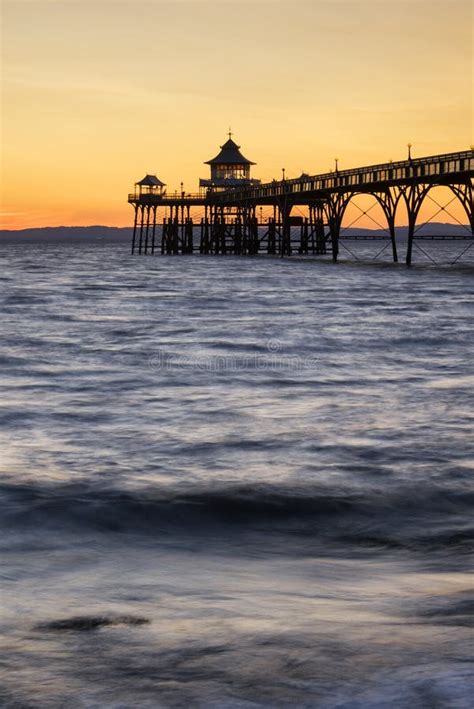 Beautiful Long Exposure Sunset Over Ocean With Pier Silhouette Stock
