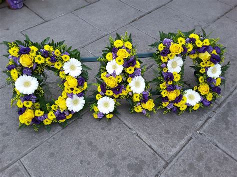 Unique themed funeral flower displays. Colourful 'DAD' tribute in yellows, whites and purples ...