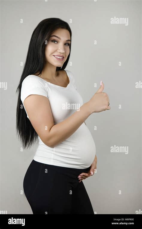 Beautiful Pregnant Brunette Woman Holding Her Pregnant Belly With One
