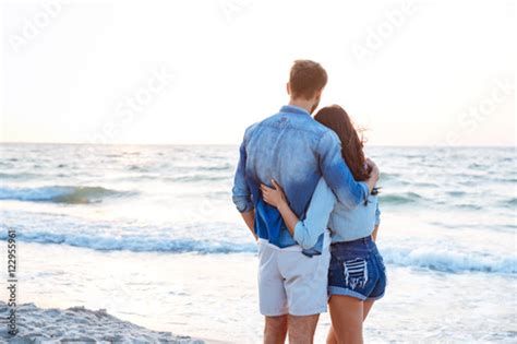 Back View Of Couple Standing And Hugging On The Beach Stockfotos Und
