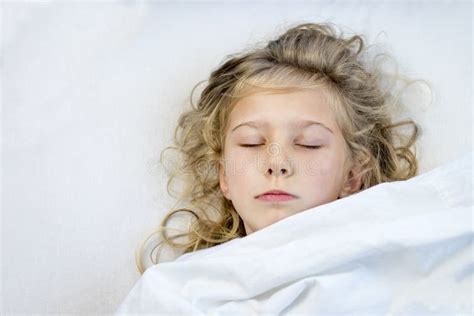 A Girl With Blond Hair She Lies In Bed Under A Blanket She Fell Asleep Stock Image Image Of
