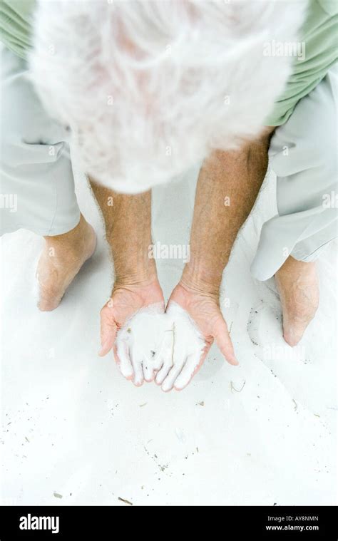 Man Bending Over Holding Sand In Both Hands High Angle View Stock Photo Alamy