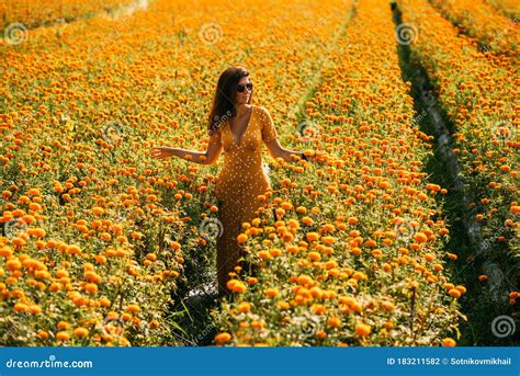 Beautiful Girl On A Flower Field A Girl In A Yellow Dress Among