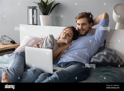 Happy Couple Cuddle In Bed Watching Laptop Stock Photo Alamy