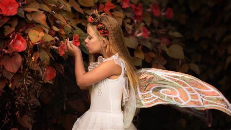 Cute Little Girl Is Having Fairy Wings And Flower Wreath Wearing White
