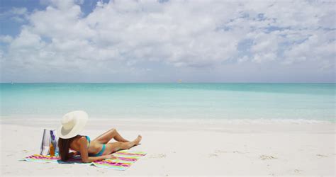 Two Women Lying Down On Their Beach Towels While Tanning Stock Footage