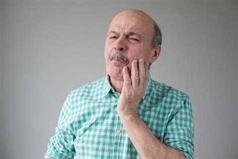 Man Feeling Pain Holding His Cheek With Hand Suffering From Bad