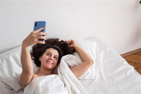 Premium Photo Woman Laying In Bed Taking Selfie On The Phone
