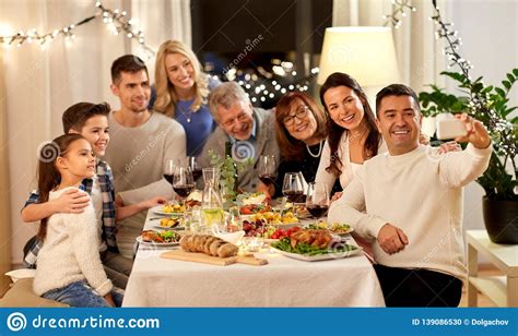 Your family can eat each part of the meal one dish at a time. Family Having Dinner Party And Taking Selfie Stock Photo ...