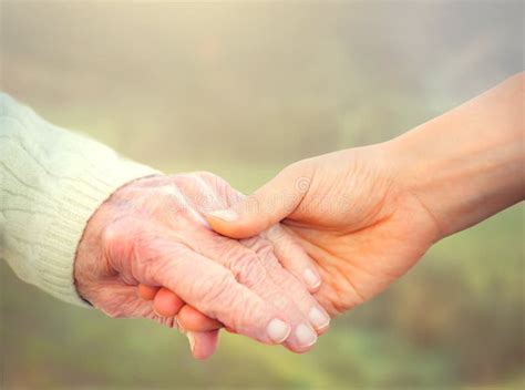 Elderly Woman Holding Hands With Young Caregiver Stock Photo Image