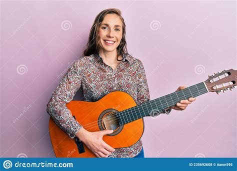 Young Blonde Woman Playing Classical Guitar Smiling With A Happy And