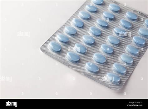 Blue oval pills in blister package on white close up Stock Photo - Alamy