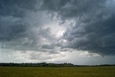 Storm Cloud Over Yellow Green Fields Forests And Hills Stock Photo