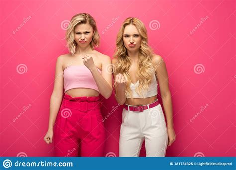 Blonde Girls Showing Fists At Camera On Pink Background Stock Image