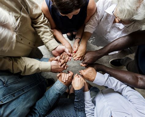Group of diverse hands holding each other support together ...